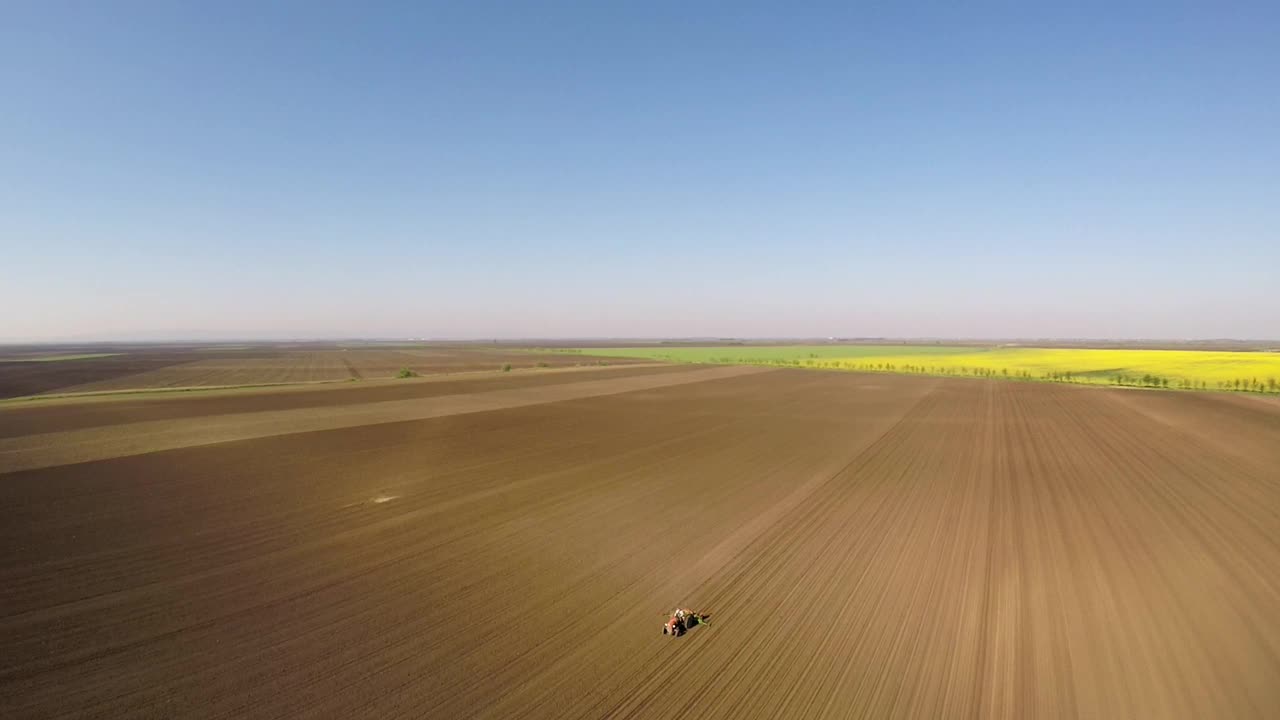 老式拖拉机播种的农民鸟瞰图。视频素材