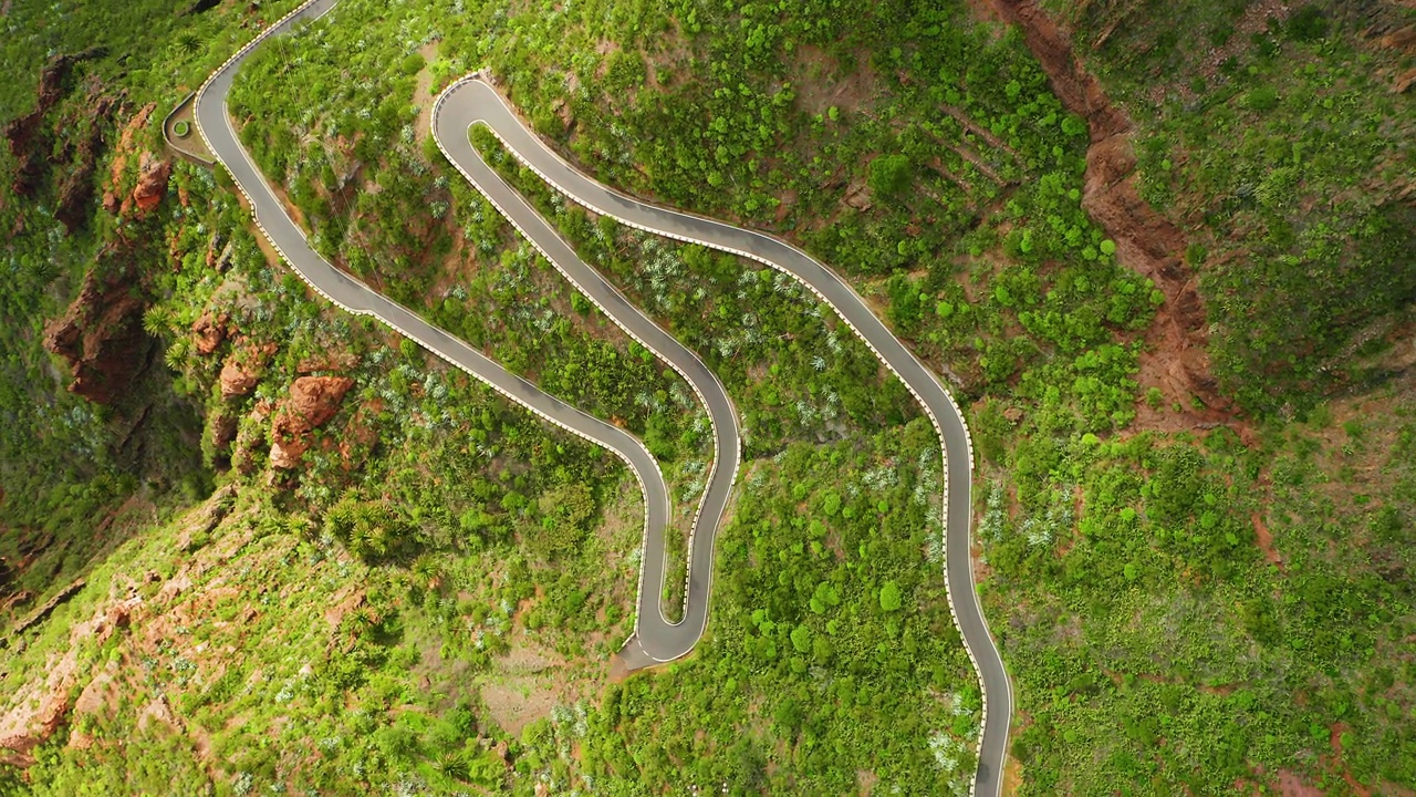 令人惊叹的风景蜿蜒的山路，从空中俯瞰绿色景观。新柏油公路铺设平整，春季山区高速公路有货车。视频素材