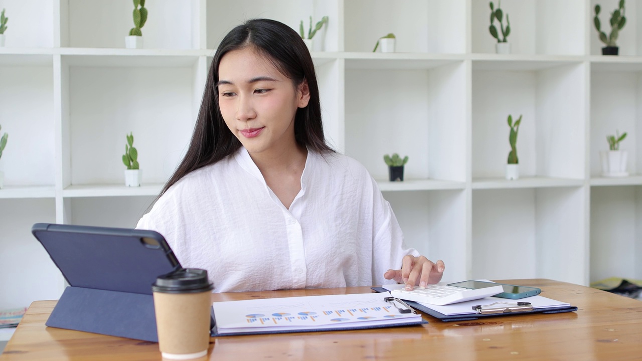 从事金融工作的女性正在使用现代计算器和笔记本电脑进行会计计算。视频素材