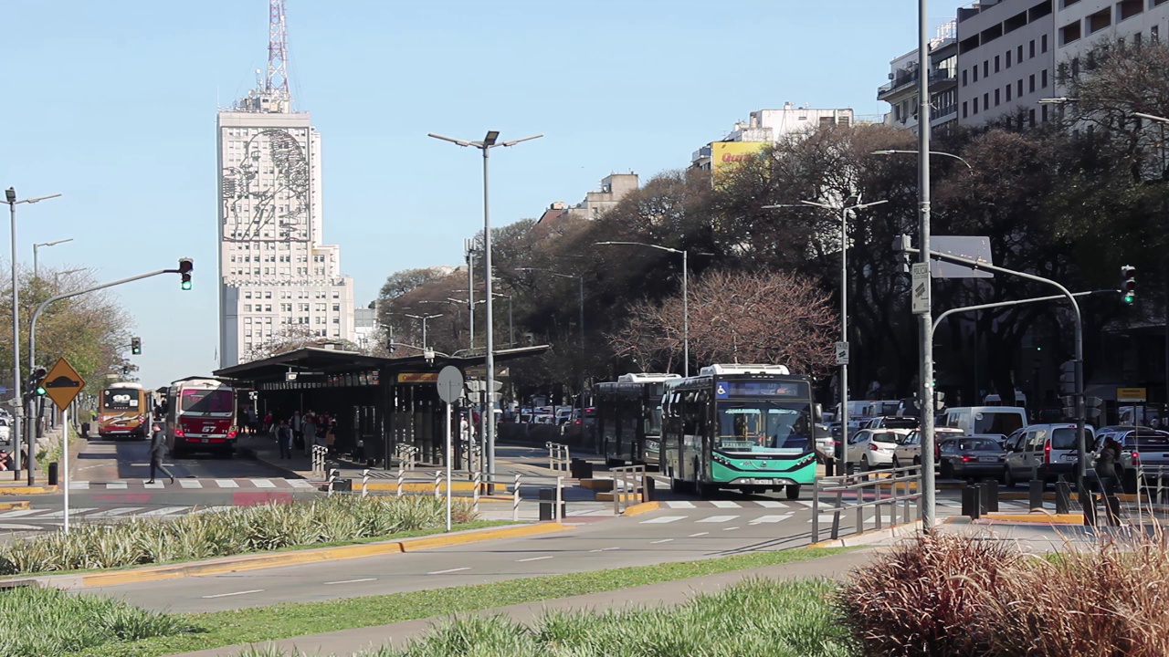 Busses on Avenida 9 de Julio with the Ministry of Public Works Building with the face of Eva Perón, better known as Evita on its Facade, Buenos Aires, Argentina. 4K Resolution.视频素材