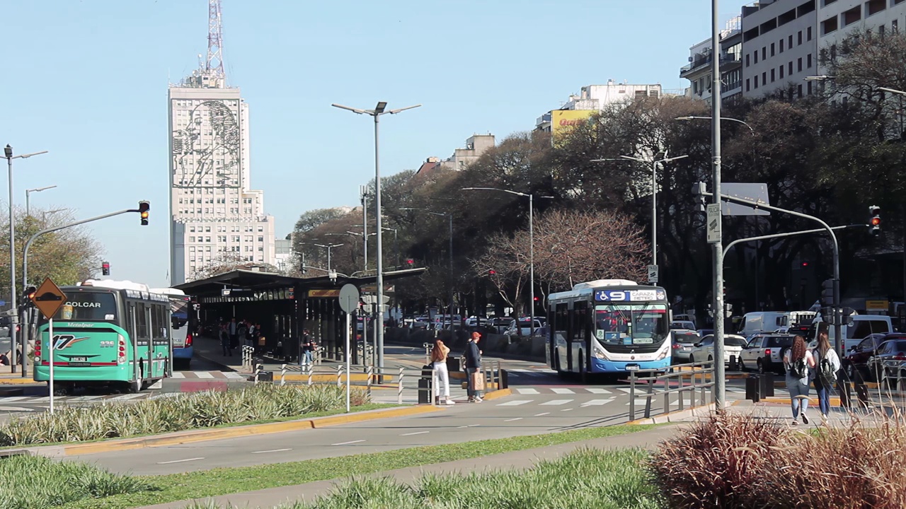 Busses on Avenida 9 de Julio with the Ministry of Public Works Building with the face of Eva Perón, better known as Evita on its Facade, Buenos Aires, Argentina. 4K Resolution.视频素材