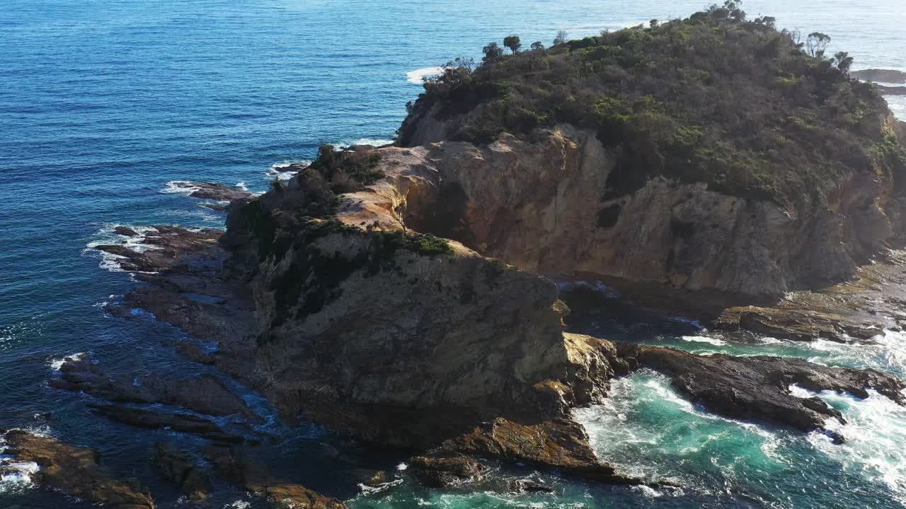 独特的海岸悬崖和岩石与蓝色的海浪碰撞视频素材