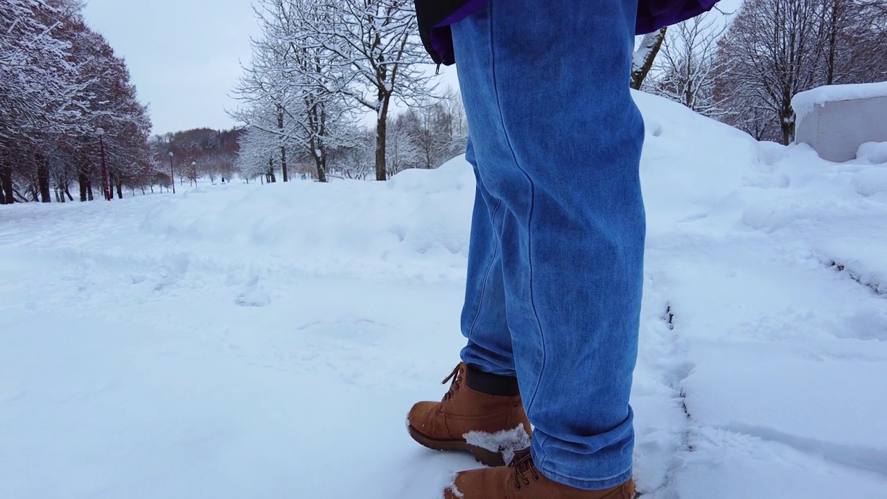 脚在雪地里。雪路上的慢镜头视频素材