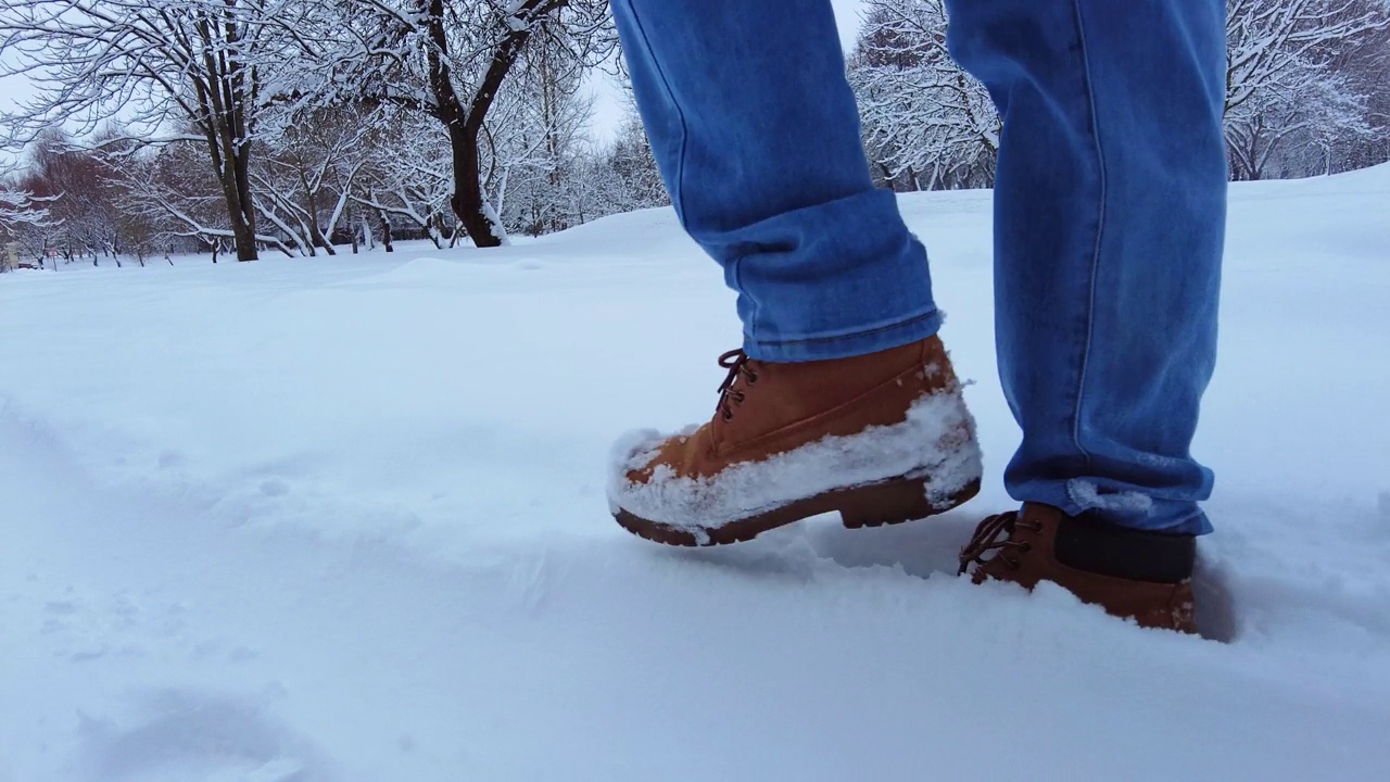 脚在雪地里。雪路上的慢镜头视频素材