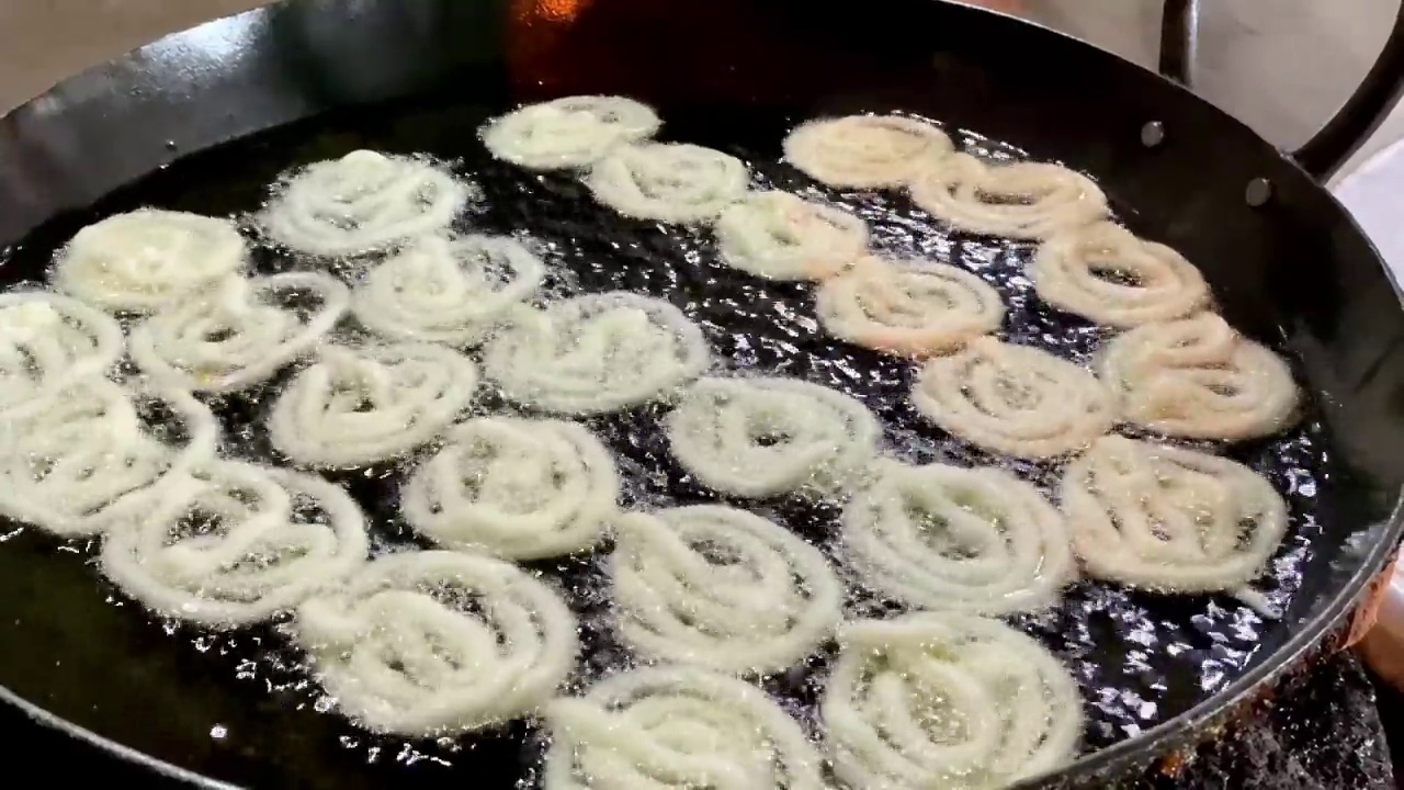 印度男子在节日上手工制作Jalebi(传统的印度油炸甜点)，印度甜点视频素材