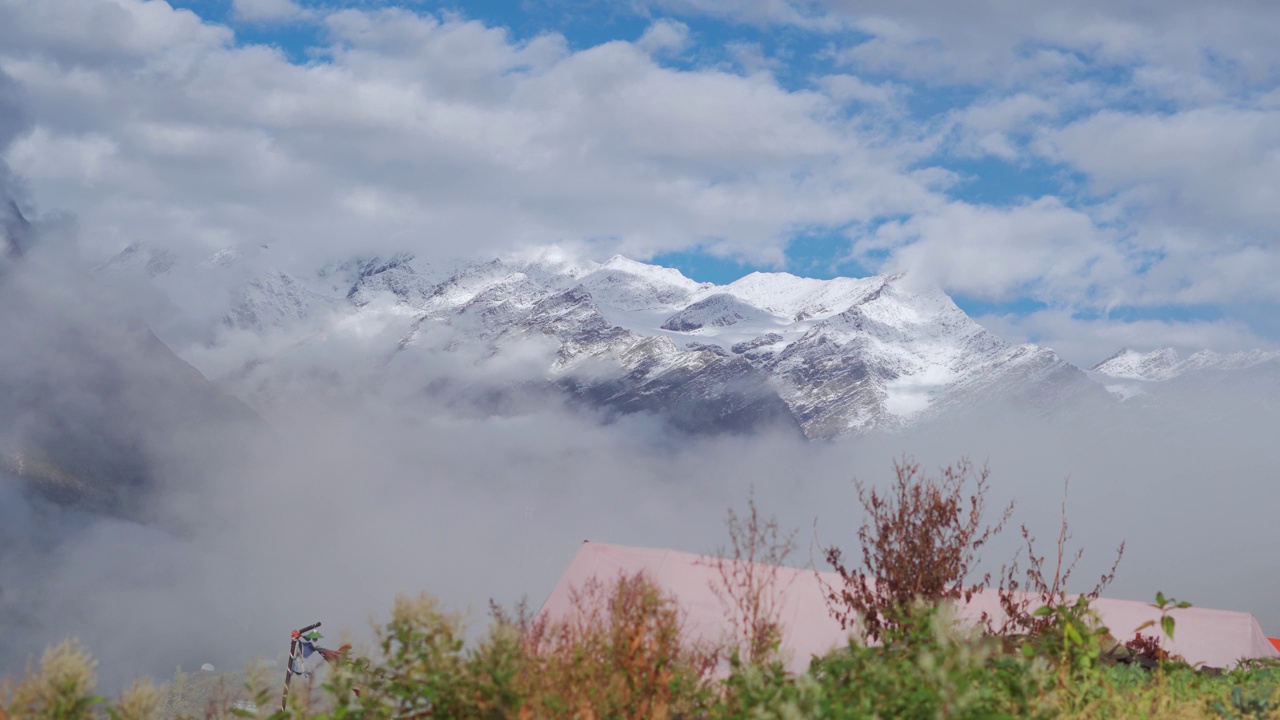 在印度喜马偕尔邦的蒂南山谷，冬季拉豪尔山脉积雪覆盖的山峰下的云的4K景观拍摄。冬天，雪下的云覆盖了山。视频素材