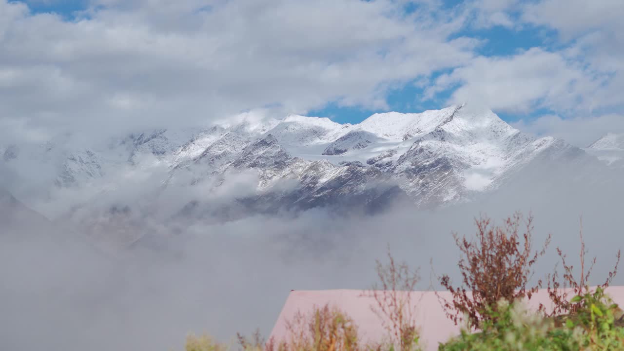 在印度喜马偕尔邦的蒂南山谷，冬季拉豪尔山脉积雪覆盖的山峰下的云的景观拍摄。冬天，雪下的云覆盖了山。视频素材