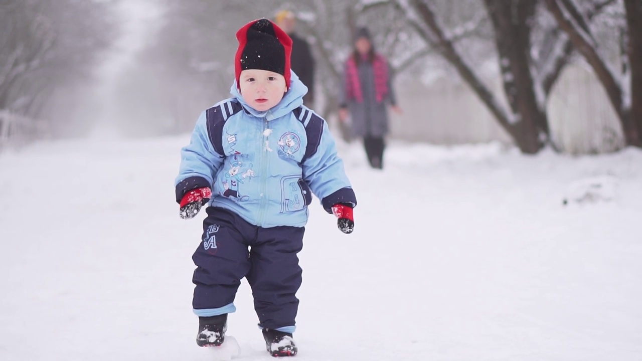 一家人在冬天打雪仗。一个雪球砸到一个孩子。有趣的寒假时光视频下载