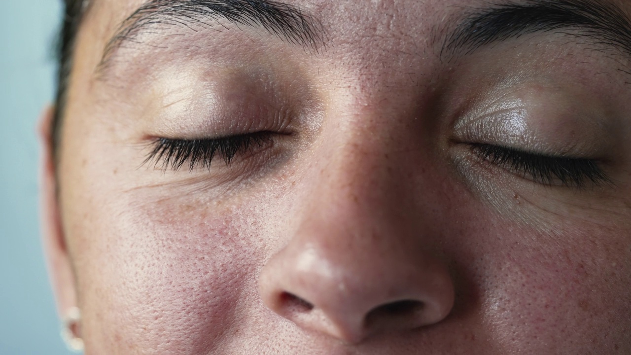 女人微笑着睁开眼睛望着天空。随意的成年女子宏观特写闭上眼睛沉思。快乐的表情视频素材