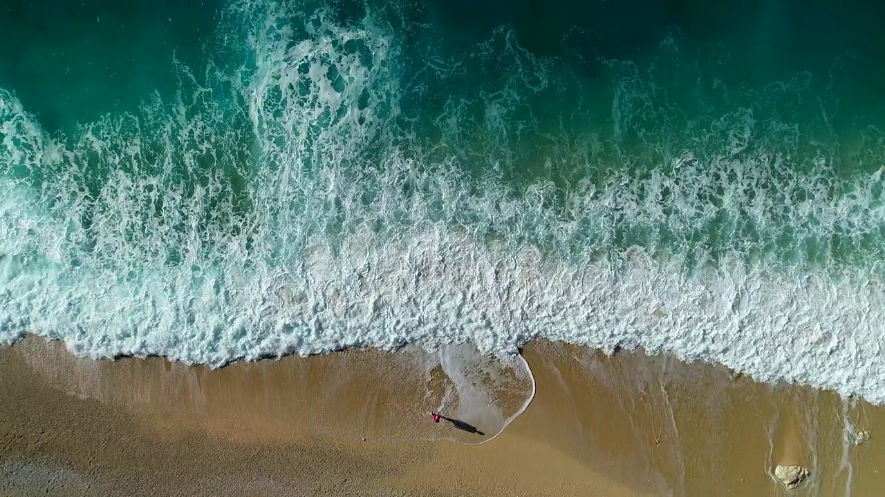 鸟瞰图的女人走在海滩与海浪的声音视频素材