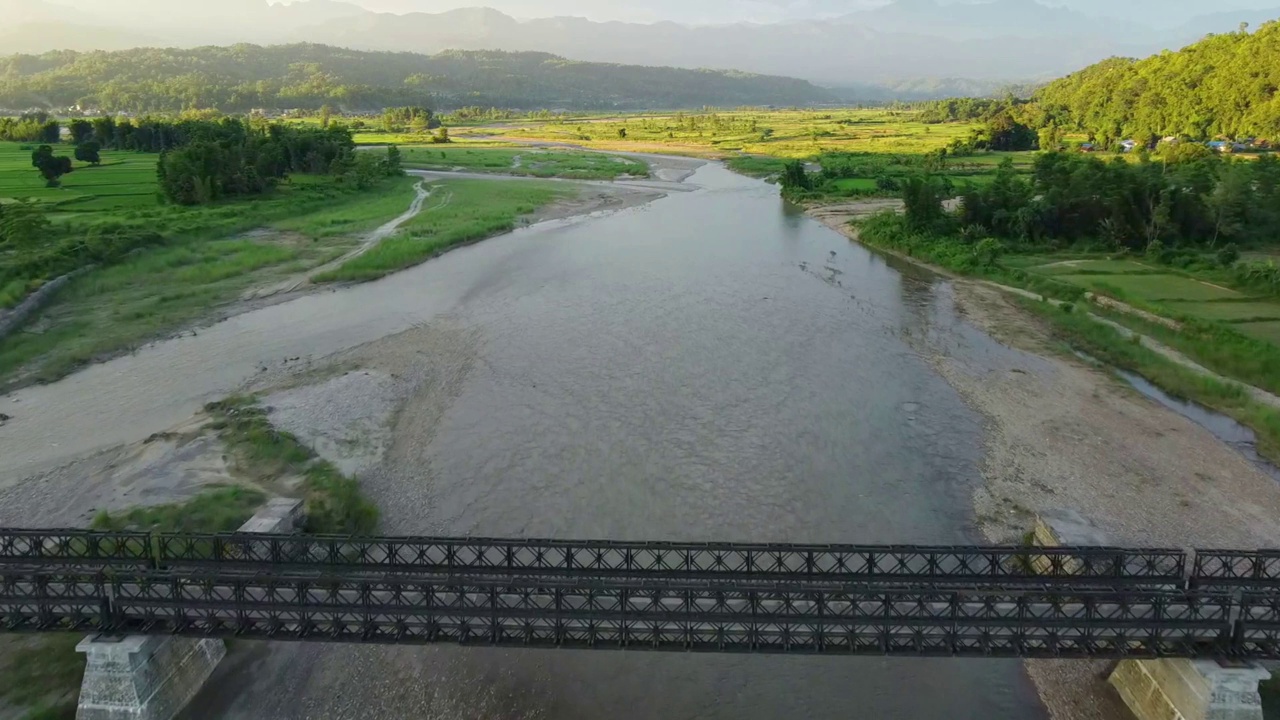 鸟瞰桥上的河流，通往绿色草地视频素材