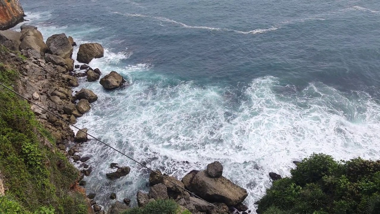 日惹海滩上悬崖上的海浪风景视频素材