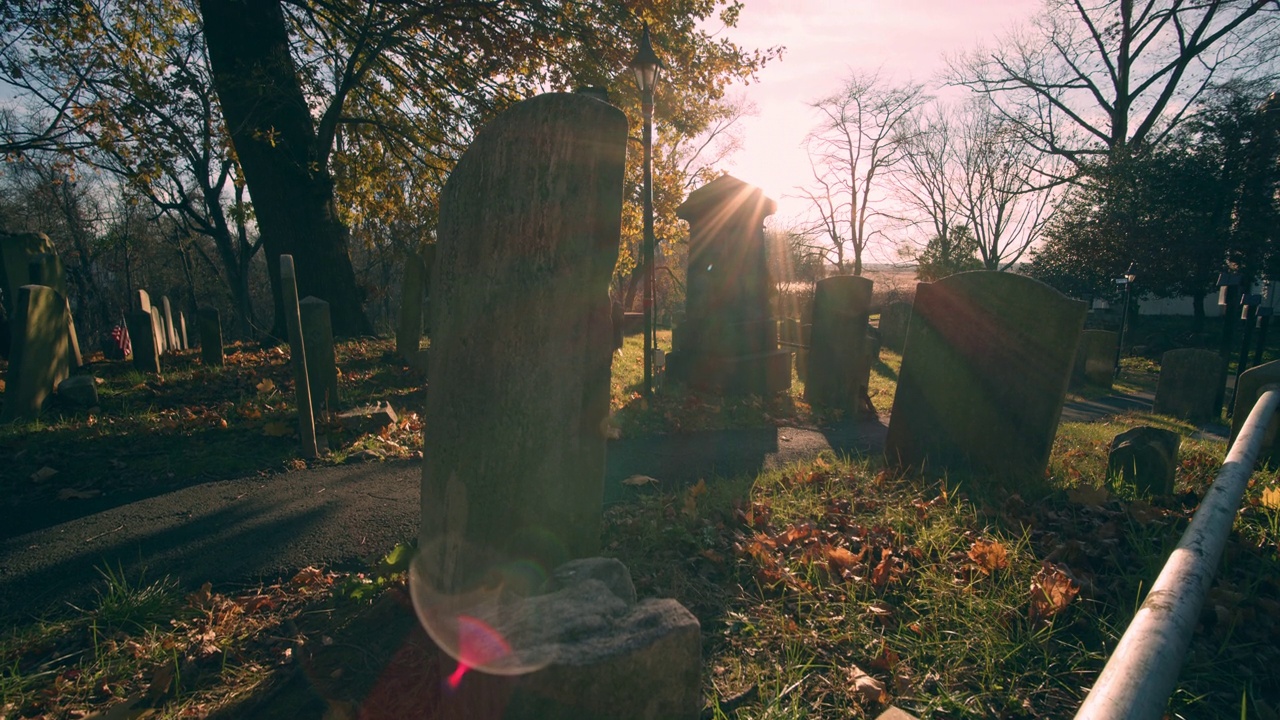 日落的镜头在墓地的墓碑上闪烁视频素材