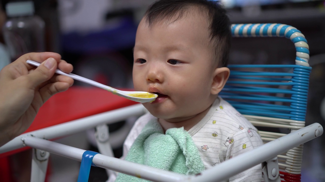 宝宝坐在宝宝椅上吃泥视频素材