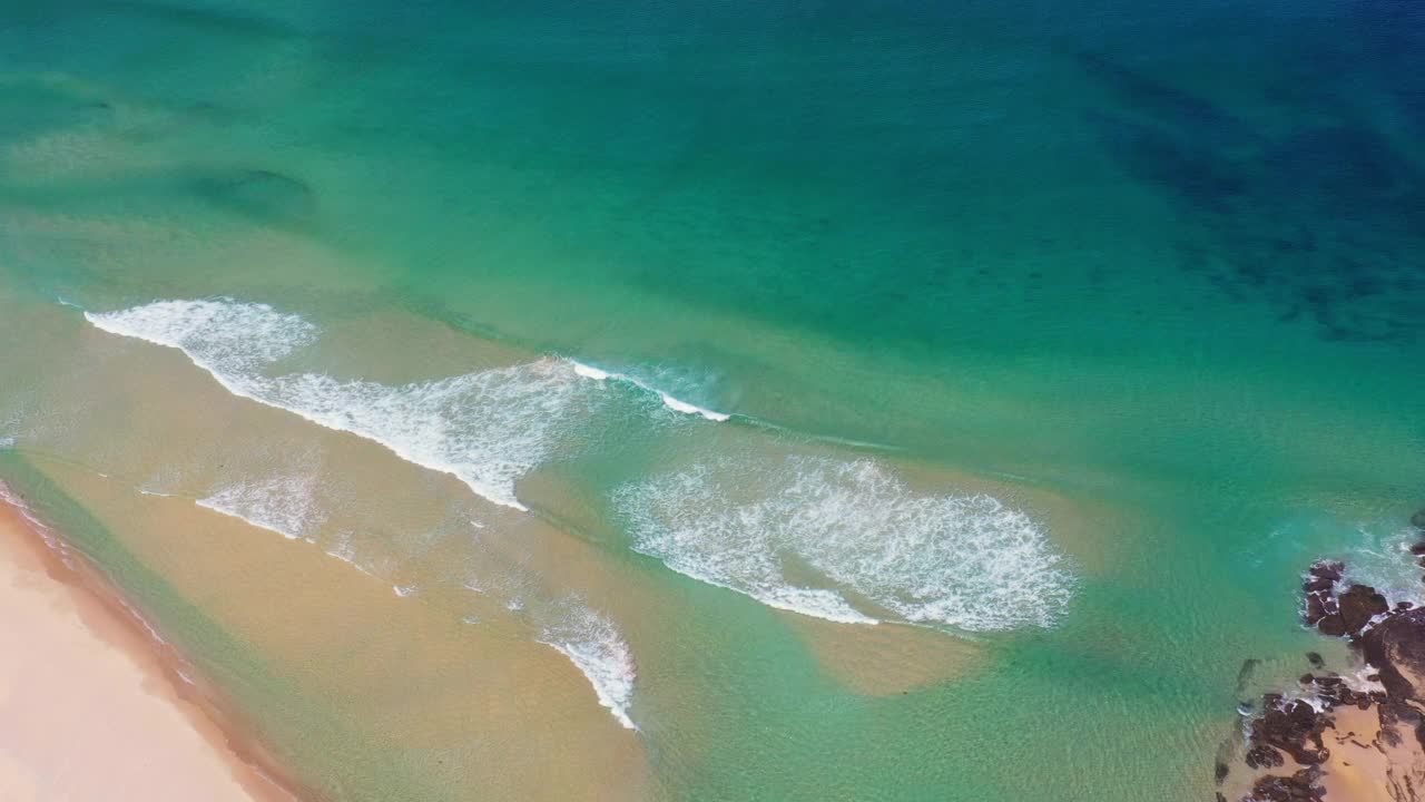 沙滩入口海岸线与海浪滚动在一个阳光灿烂的日子视频素材