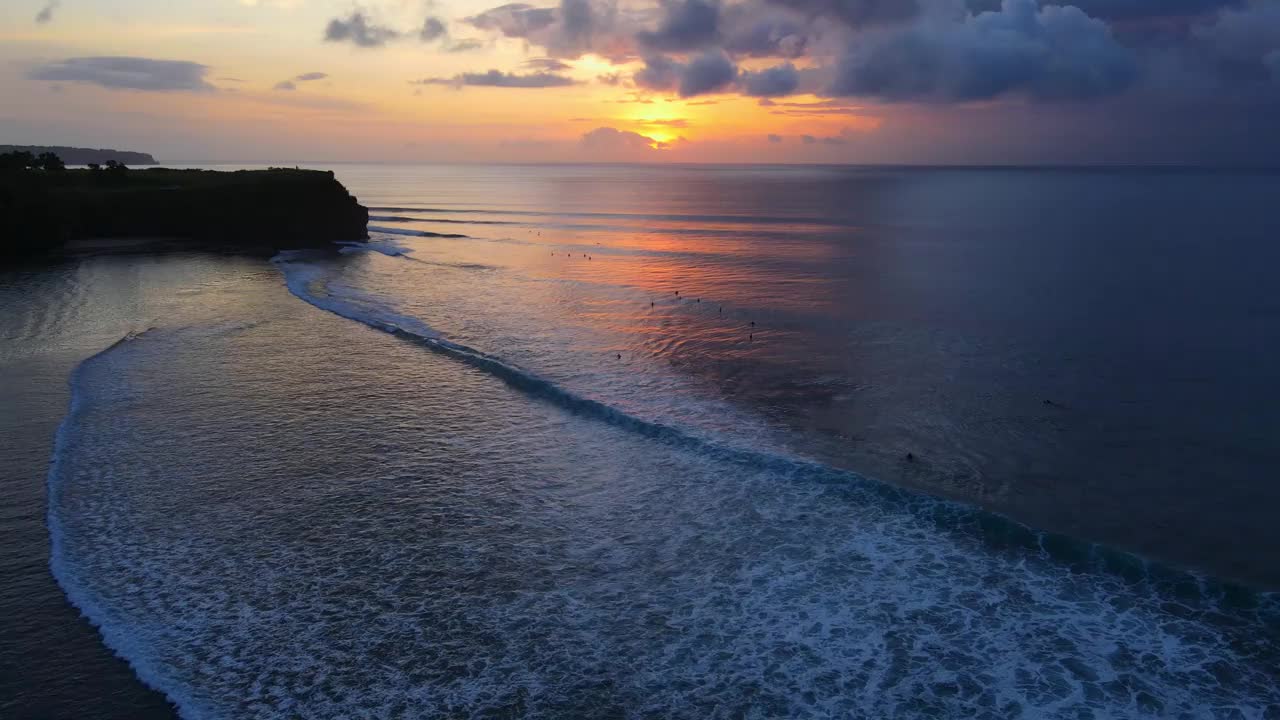 在巴厘岛的巴兰甘海滩，鸟瞰海洋，海浪，冲浪者和多彩的日落或日出。视频素材