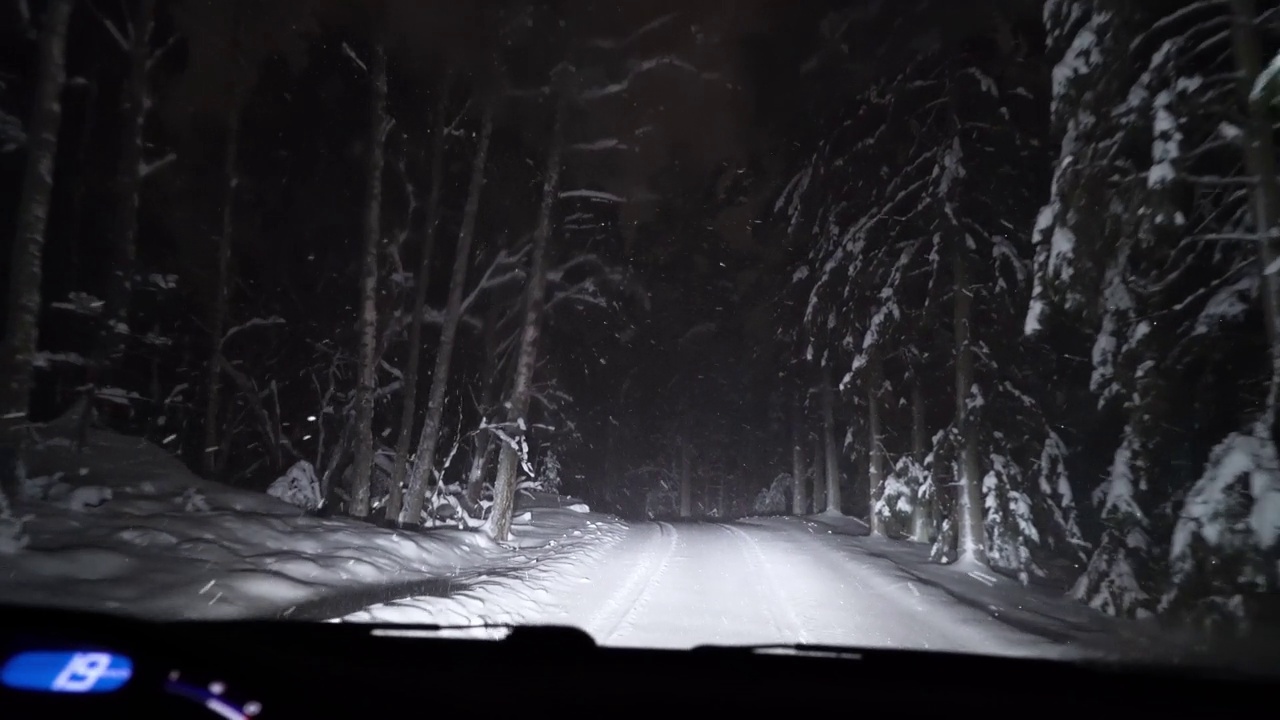 夜间驾驶森林积雪的道路。视频素材