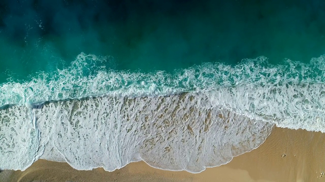 鸟瞰清晰的蓝绿色大海和海浪视频素材