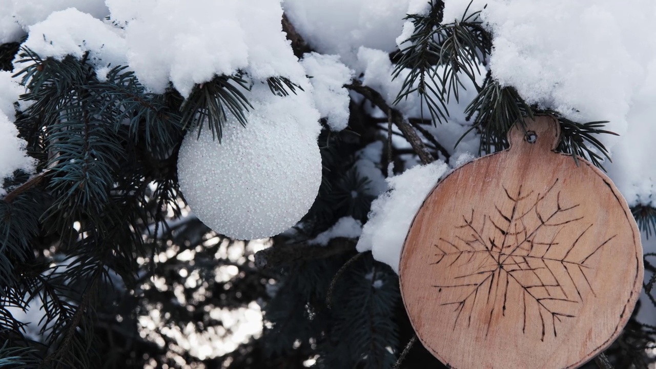 自制的木制玩具放在白雪覆盖的圣诞树上。视频素材