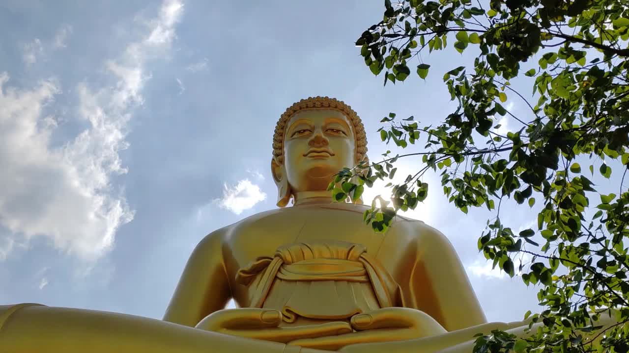 前视图金大佛(佛祖法玛卡耶)在笏白南Phasi Charoen寺。阳光天空和云的背景视频素材