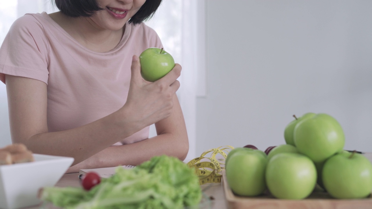 女性喜欢饮食，所以吃水果和蔬菜沙拉配青苹果。女性选择健康的食物会感到快乐。健康饮食和减肥的概念。视频素材