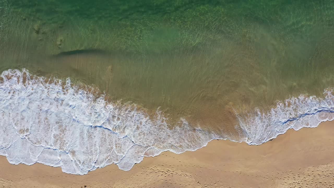 温暖的沙滩海岸线，海浪滚滚而来视频素材