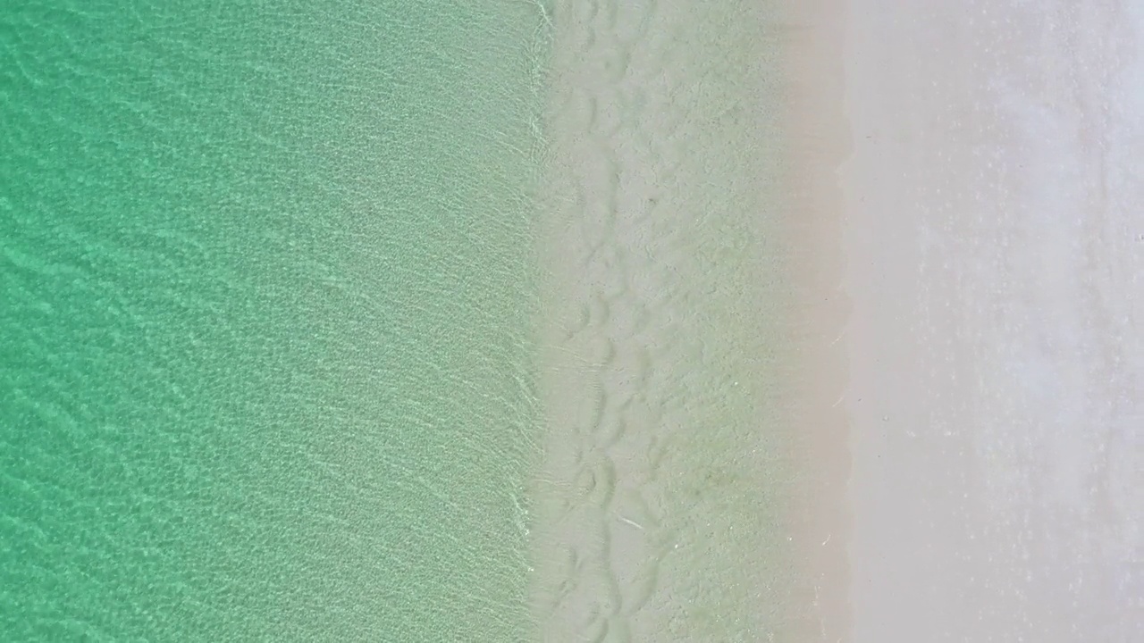 直接在空旷的白色沙滩海岸线与蓝绿色平静的海湾的水视频素材