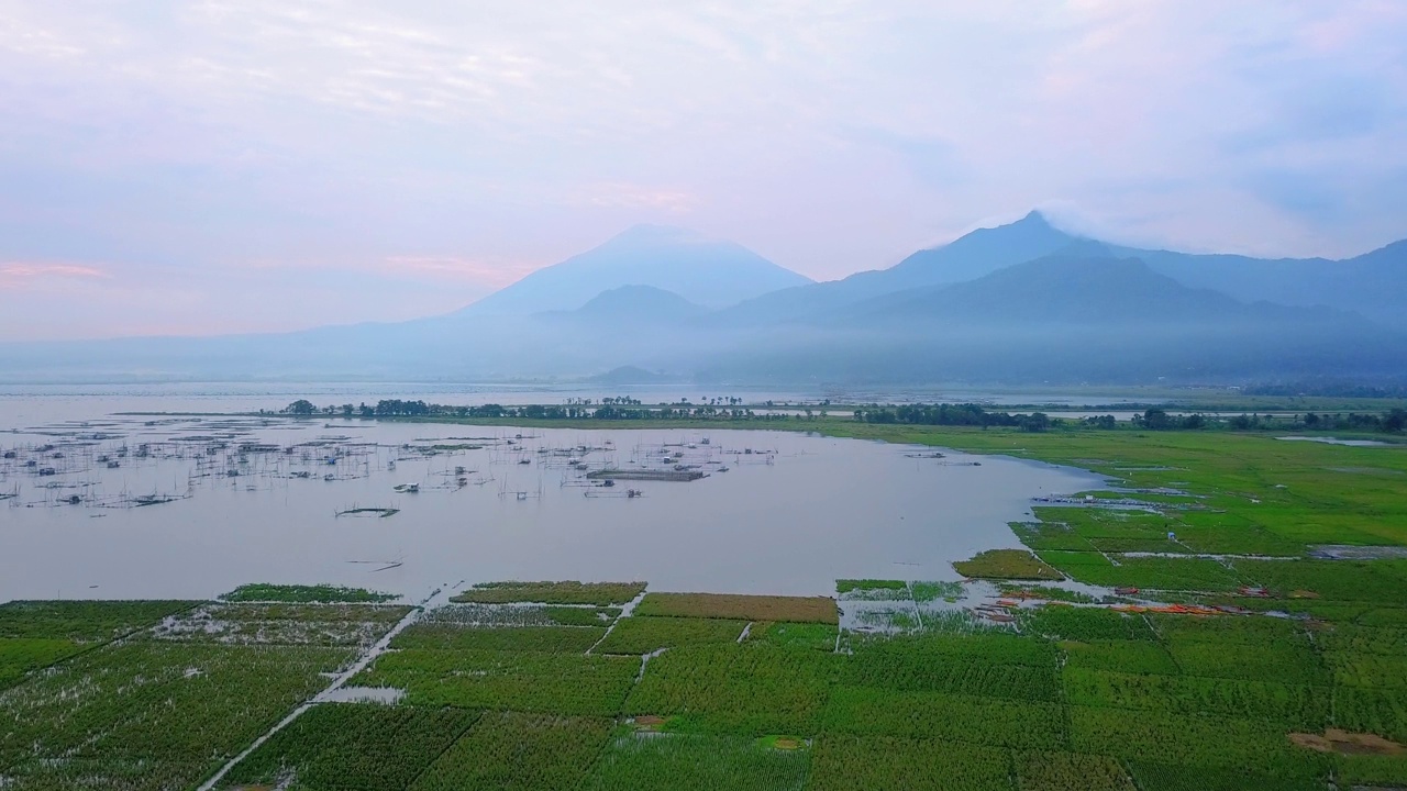 无人机拍摄的巨大的湖泊，日出的天空和山的背景-拉瓦平湖，中爪哇，印度尼西亚视频素材