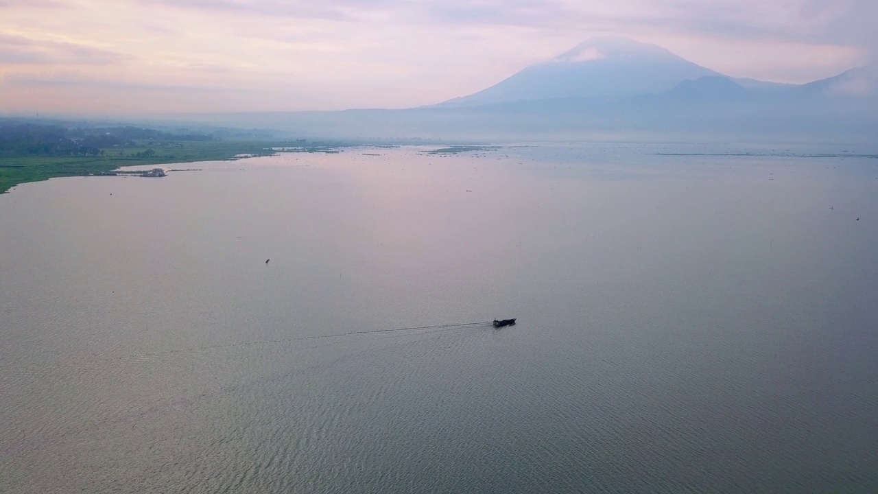 无人机拍摄的巨大湖泊与渔民船。看到日出的天空和山的背景-拉瓦平湖，中爪哇，印度尼西亚视频素材