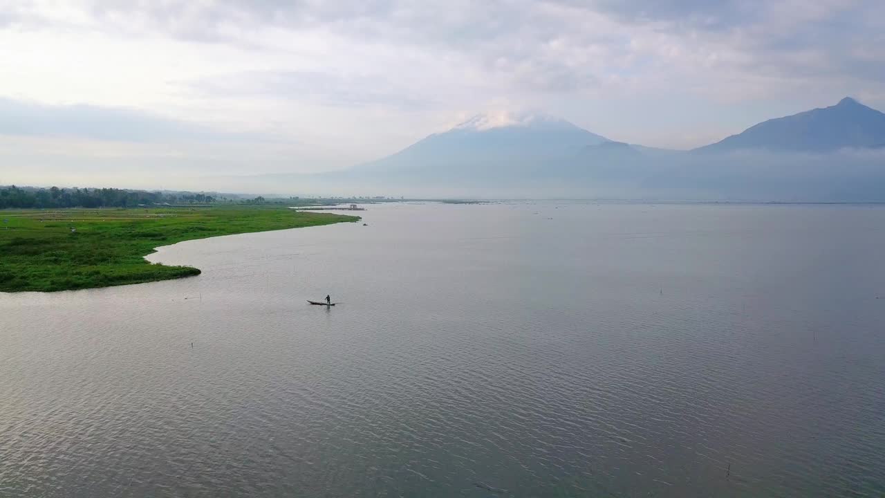 无人机拍摄的巨大湖泊与渔民船。看到日出的天空和山的背景-拉瓦平湖，中爪哇，印度尼西亚视频素材