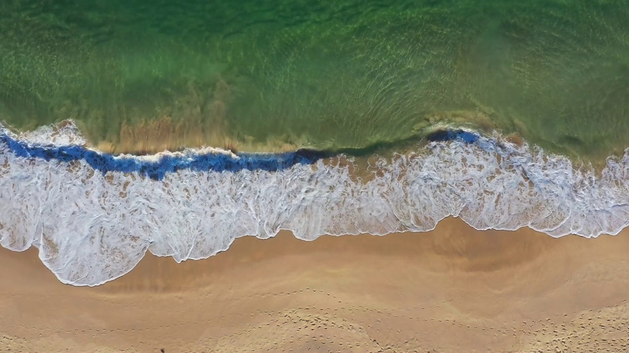 温暖的沙滩海岸线，海浪滚滚而来视频素材