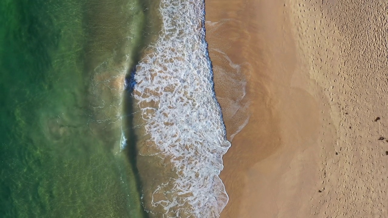 温暖的沙滩海岸线，海浪滚滚而来视频素材