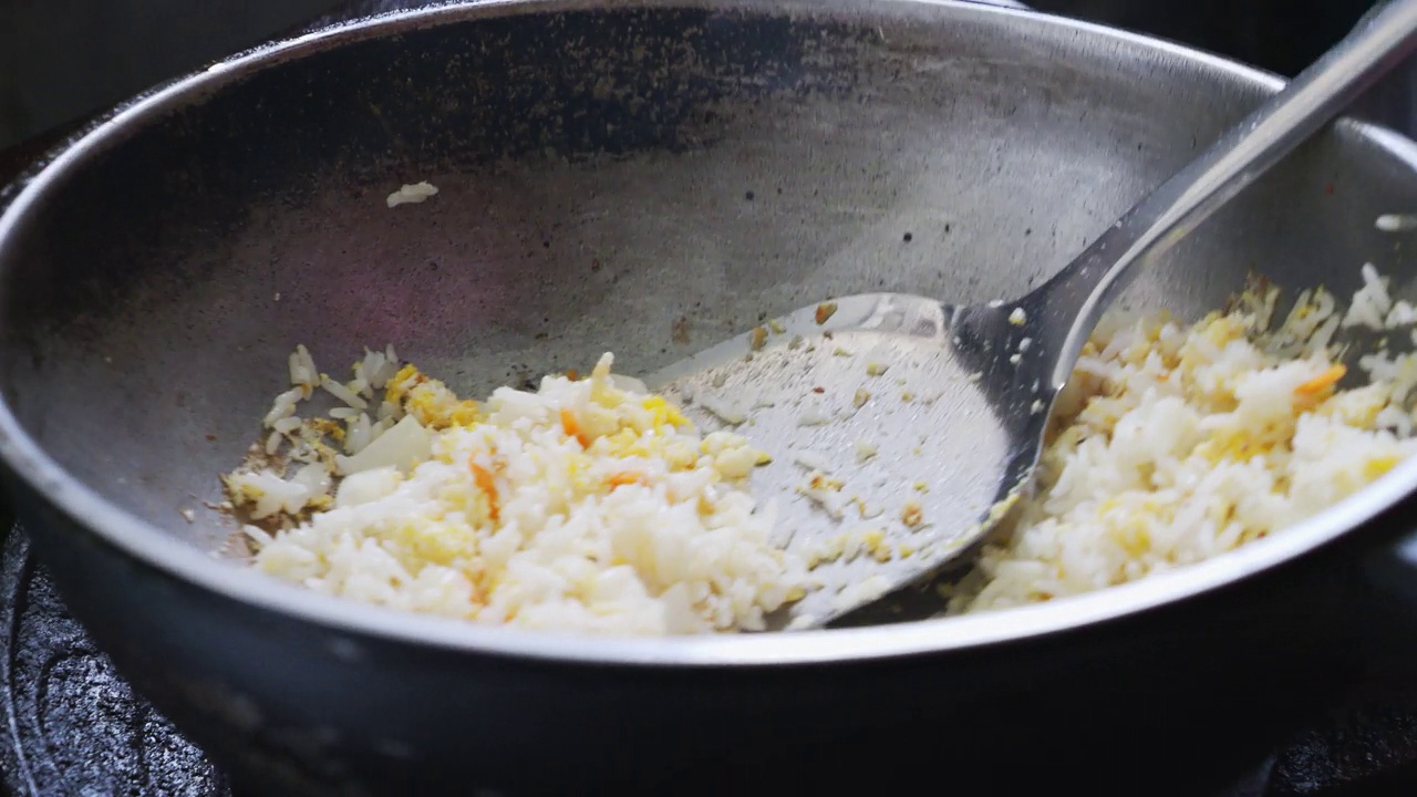 厨师正在炉子上的热锅里做炒饭。视频素材