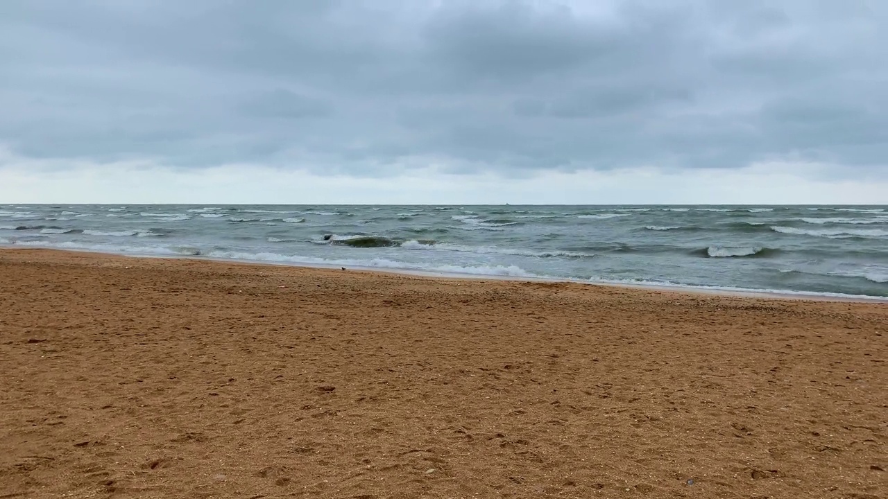 在阴天，海浪在沙滩上翻滚。视频素材