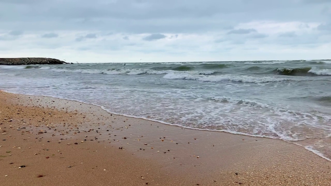 在阴天，海浪在沙滩上翻滚。视频素材