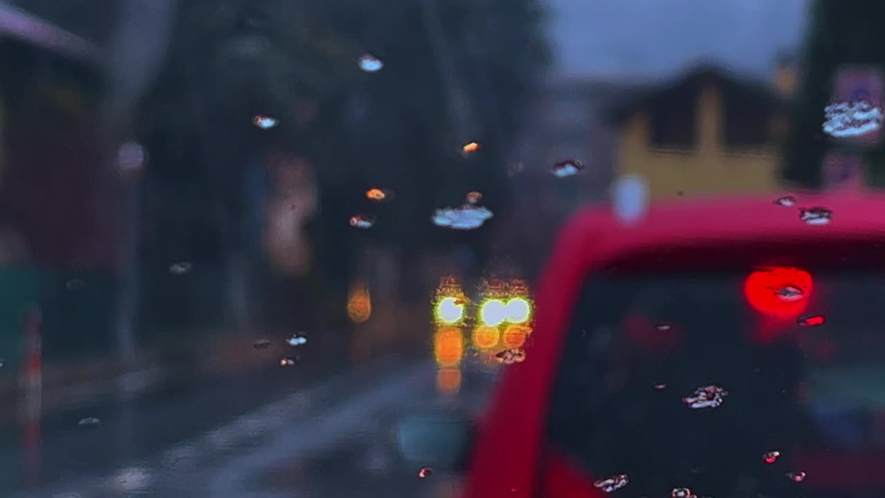 特写抑郁的坏天气与雨和雨夹雪滑在雾的挡风玻璃和模糊的汽车交通灯光的背景视频素材