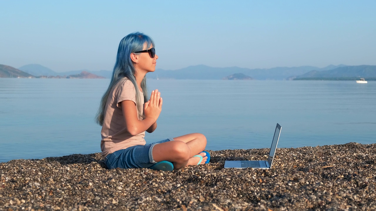 海滩上的女孩在线瑜伽。视频素材