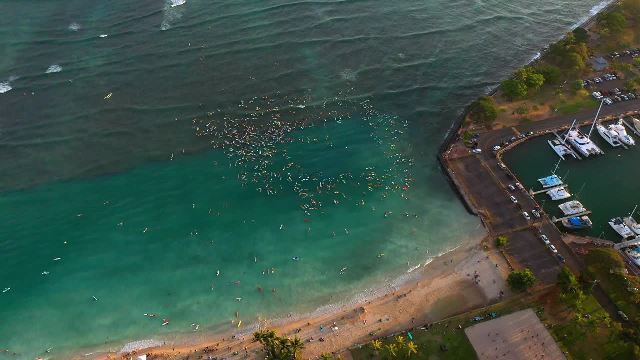 空中向前倾斜向下拍摄的游客聚集在海边的冲浪板海滩-瓦胡岛，夏威夷视频素材