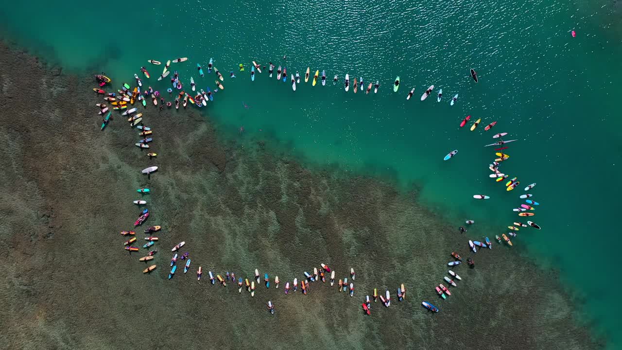 人们在度假期间带着冲浪板漂浮在海上的航拍顶部平移镜头——夏威夷瓦胡岛视频素材