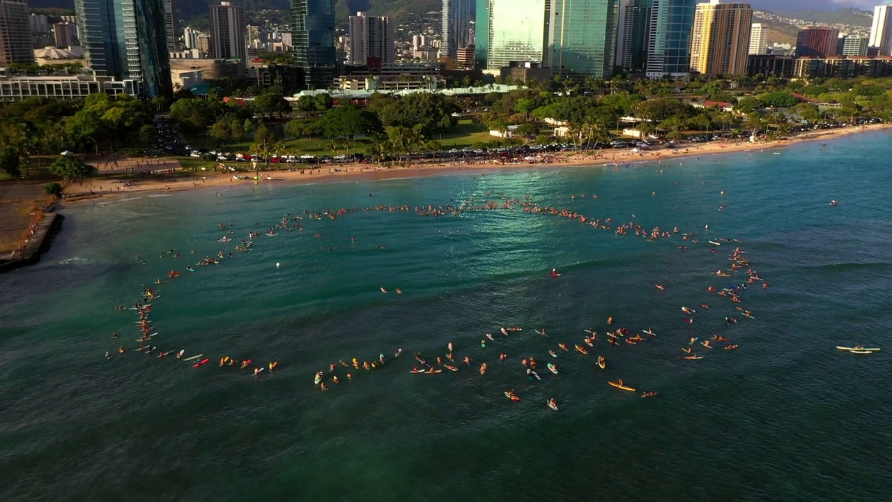 在夏威夷瓦胡岛的海滩上，人们用冲浪板漂浮在海里的航拍镜头视频素材