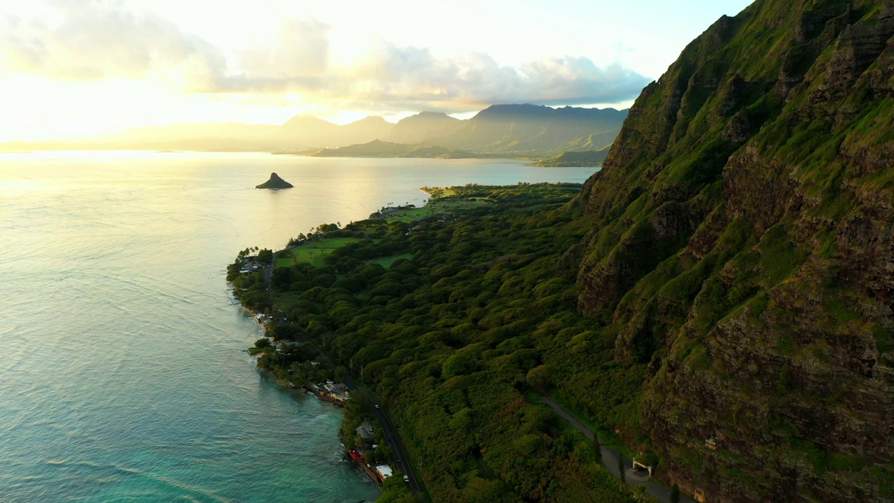 空中拍摄的山在海上对天空，无人机在海岸线上向后飞行-夏威夷卡内奥赫视频素材