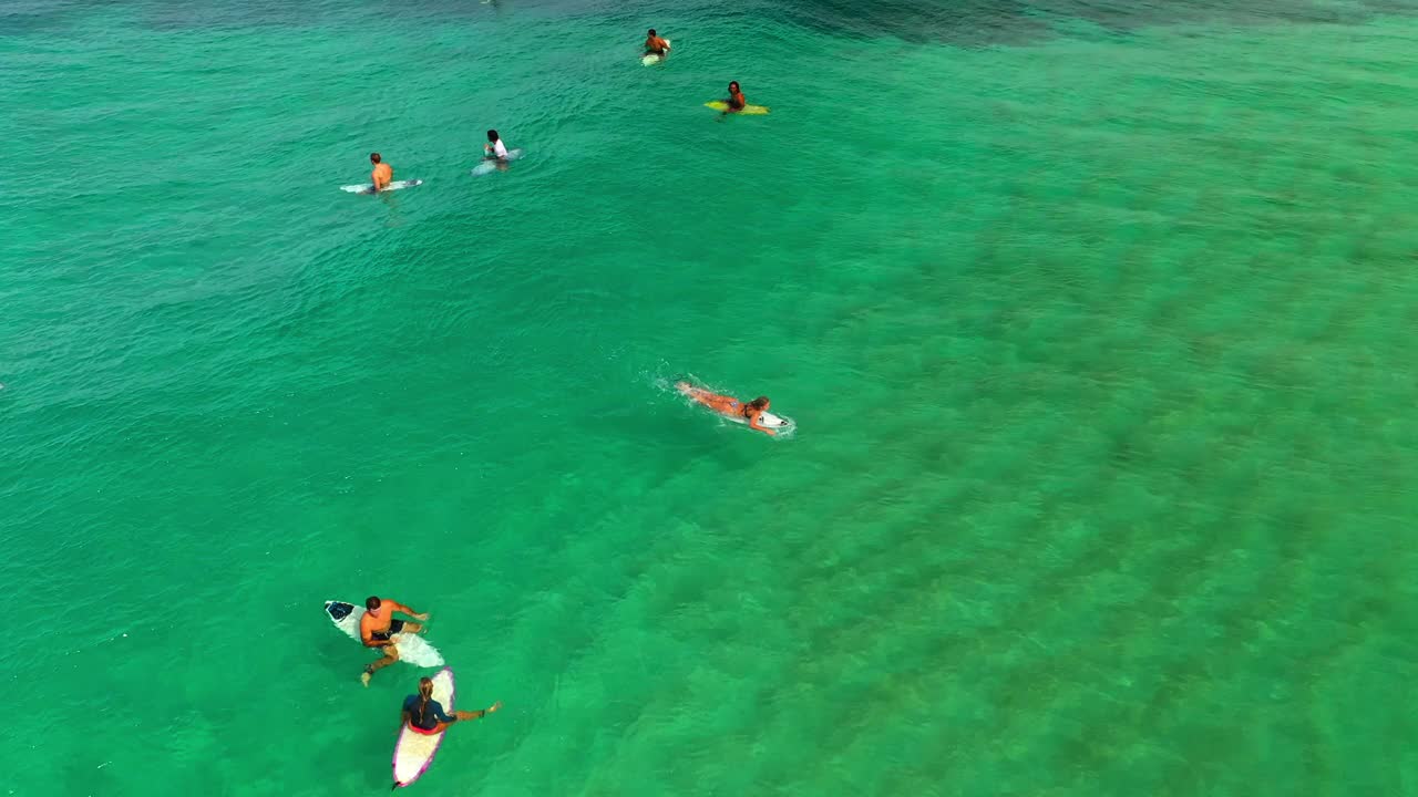 空中向后拍摄的女子在度假期间的蓝色大海冲浪-夏威夷瓦胡岛视频素材