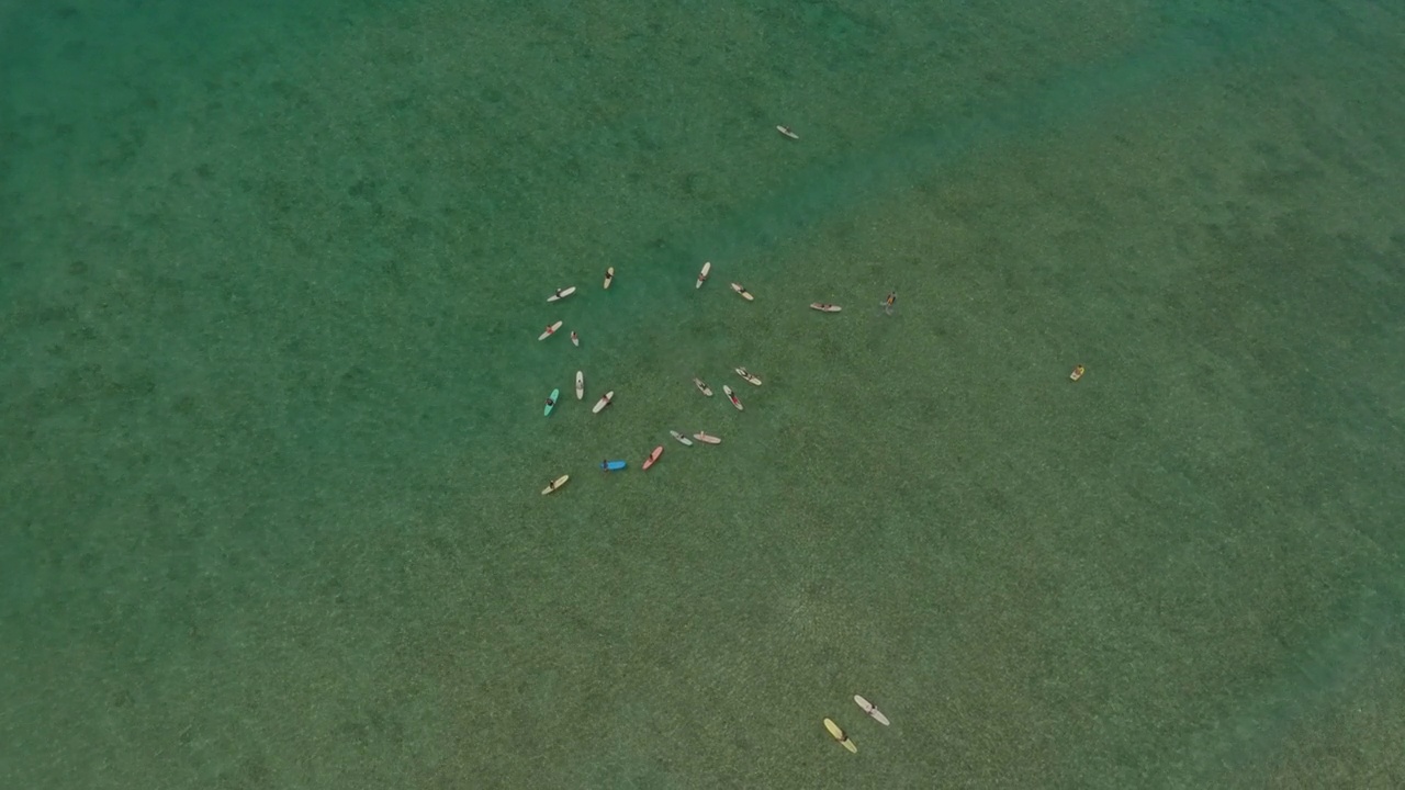 空中平移下降拍摄的游客与冲浪板漂浮在海上度假-威基基，夏威夷视频素材