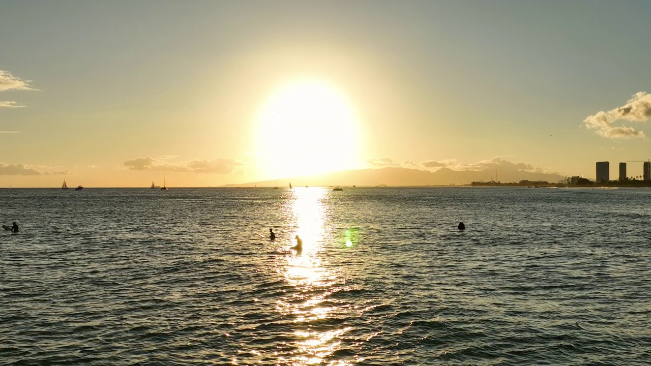 日落时分人们在海上冲浪板的慢动作封锁剪影——夏威夷威基基视频素材