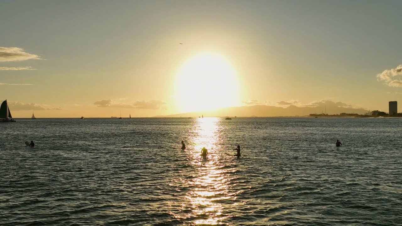 慢镜头的人漂浮在海浪海浪日落时冲浪板-威基基，夏威夷视频素材