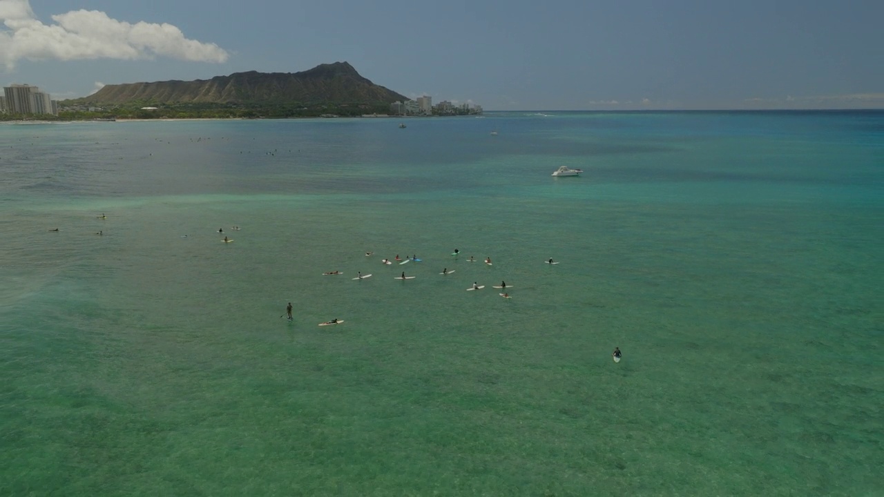 空中向后倾斜拍摄的游客与冲浪板在瓦胡岛在阳光灿烂的一天-夏威夷威基基视频素材