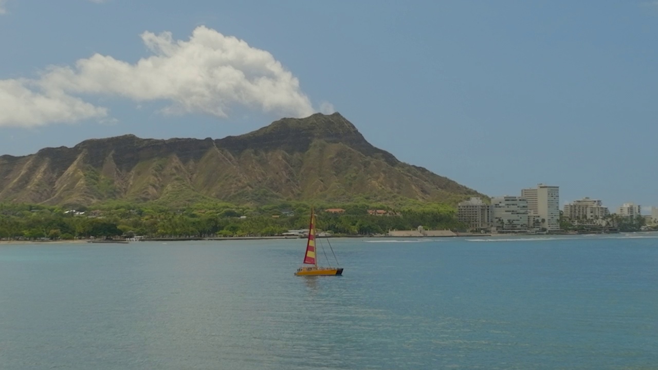 帆船在瓦胡岛波涛汹涌的海面上移动，顶着多云的天空-夏威夷威基基视频素材