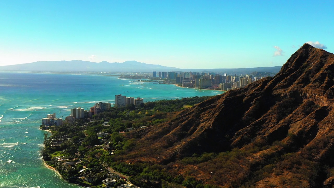 空中向上拍摄的山与车辆和建筑物在晴天蓝色的海-瓦胡岛，夏威夷视频素材