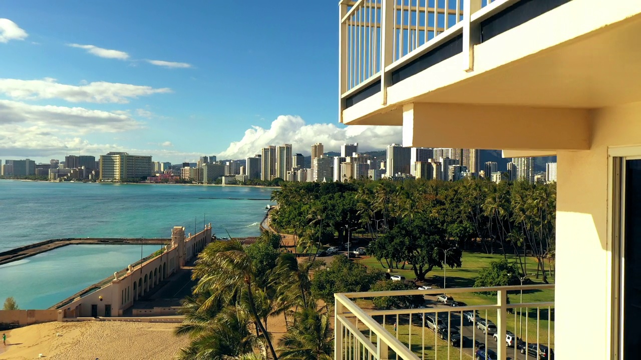 空中向下拍摄的空阳台，在阳光明媚的日子里，树木和停在海边的汽车——夏威夷瓦胡岛视频素材