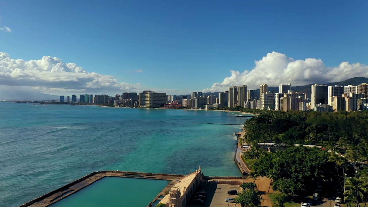 空中向前游泳池与蓝色的大海对建筑物在晴天-瓦胡岛，夏威夷视频素材